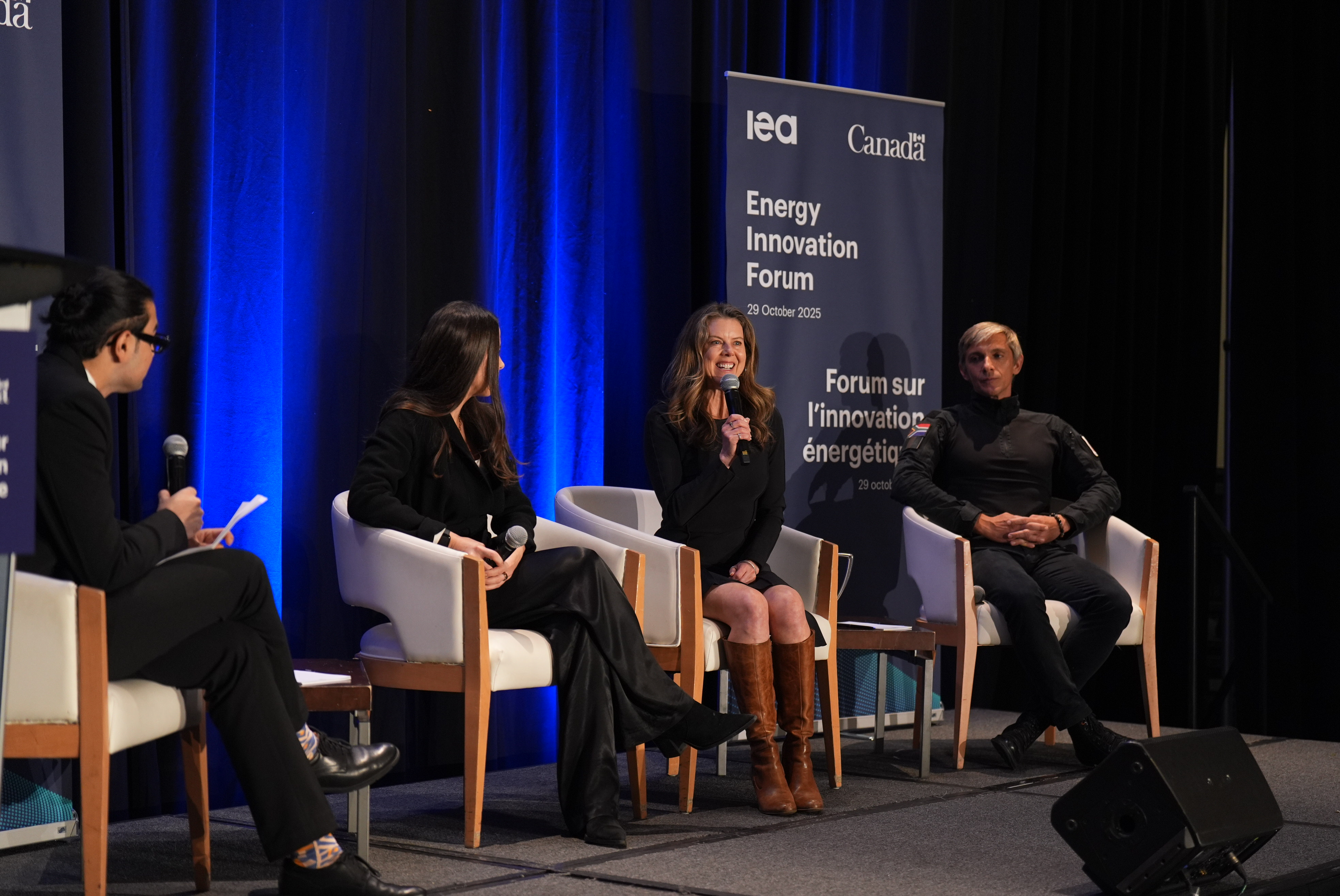 4 panelists sitting on stage in front of the Energy Innovation Forum banner. 