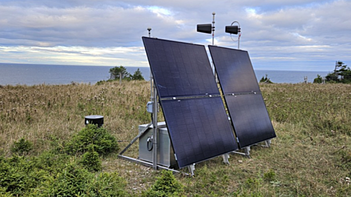 A remote Earthquake Early Warning station in Quebec situated on a hillside overlooking a body of water.