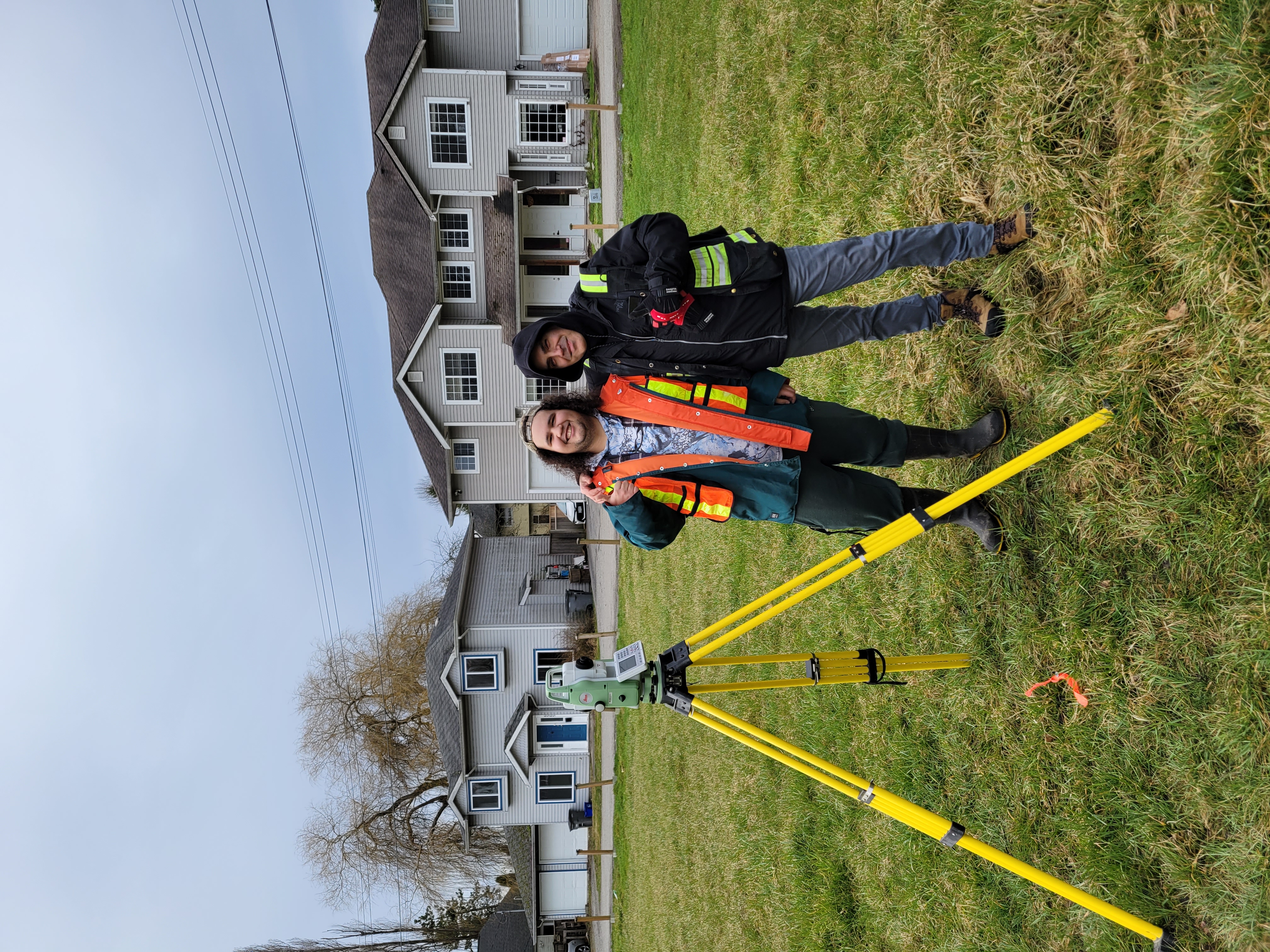 Two people with land surveying equipment at Musqueam.