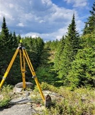 Survey tripod installed in a wooded area on the international boundary in the Highlands Section, East of Saint Théophile (QC) and Maine.