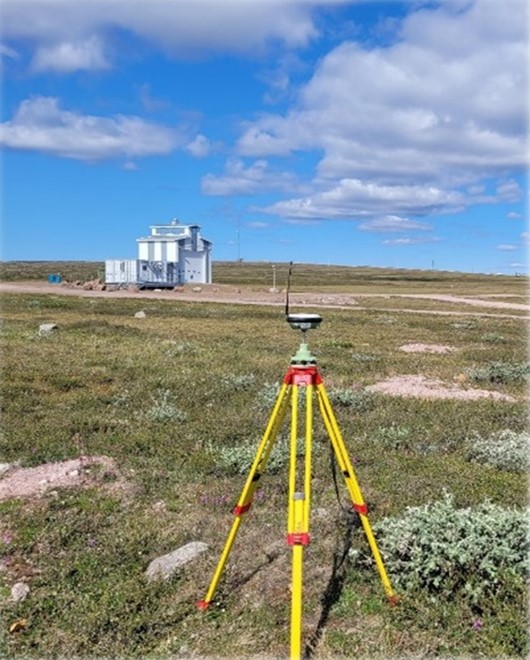 Land surveying equipment overlooking a building Baker Lake, Nunavut.