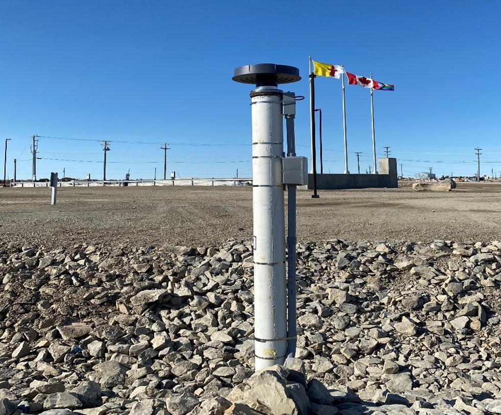 High Arctic research station in Cambridge Bay, Nunavut with hydro poles and flags in the background.