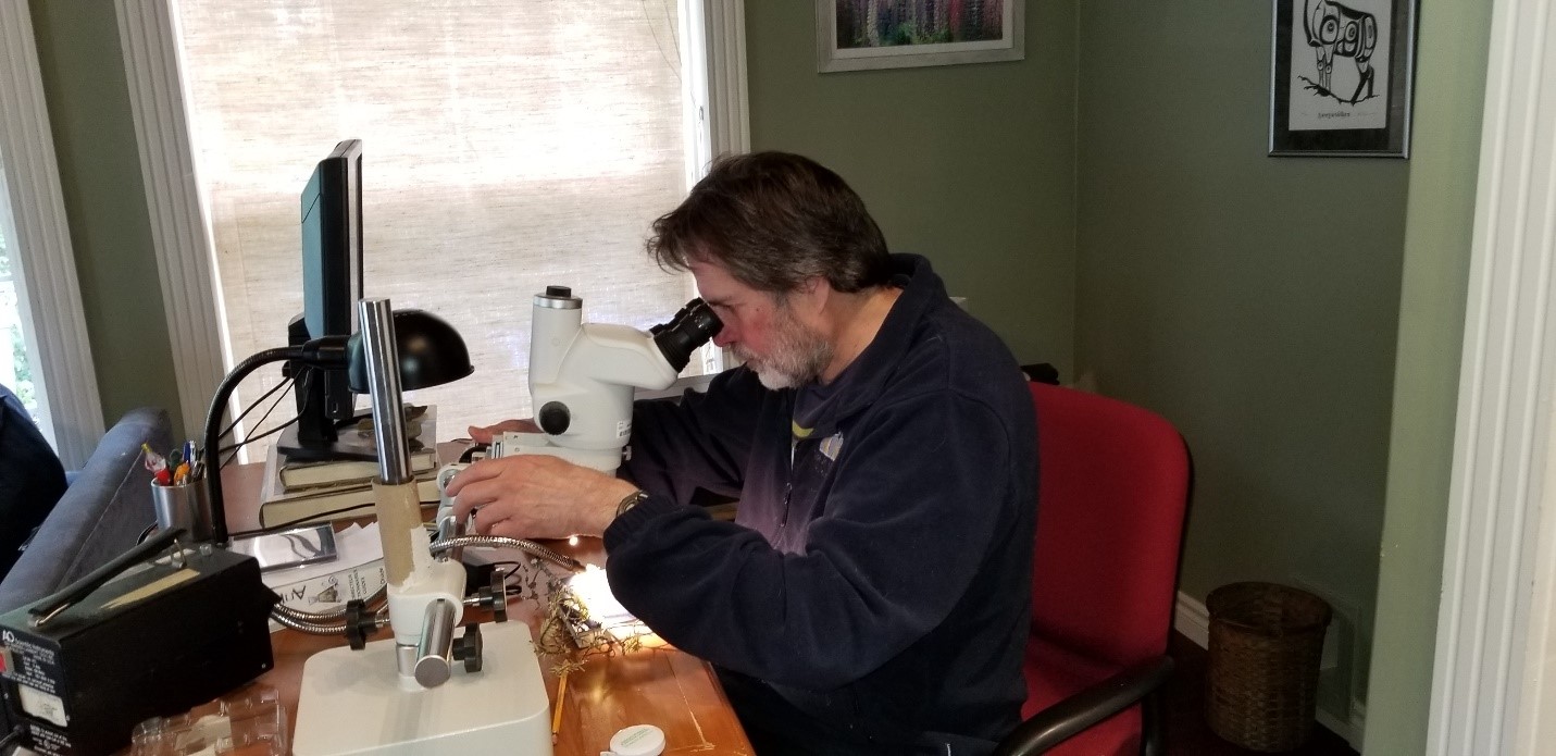 A man examines a specimen under a microscope